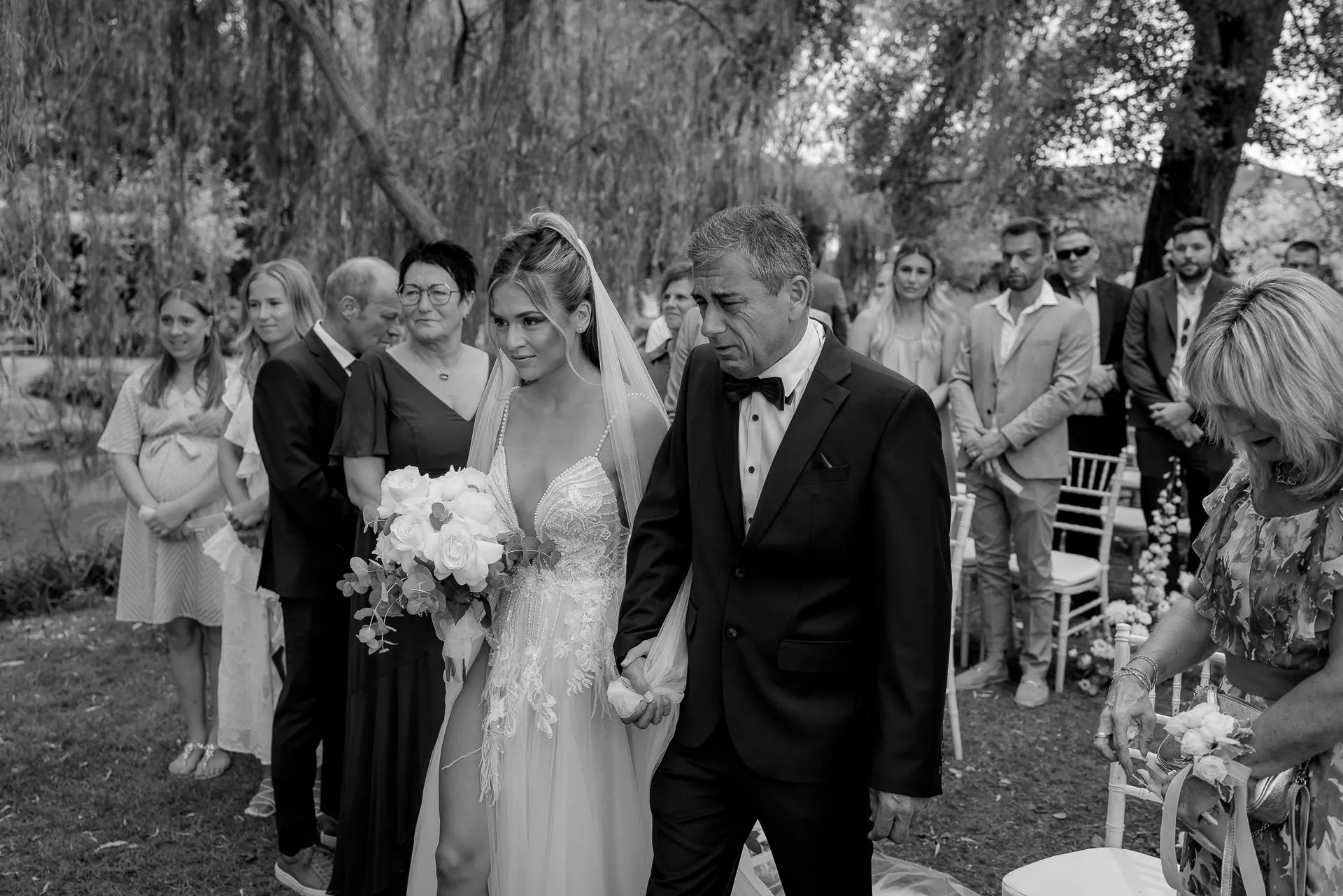 Emotional bride with father and white bouquet during wedding ceremony