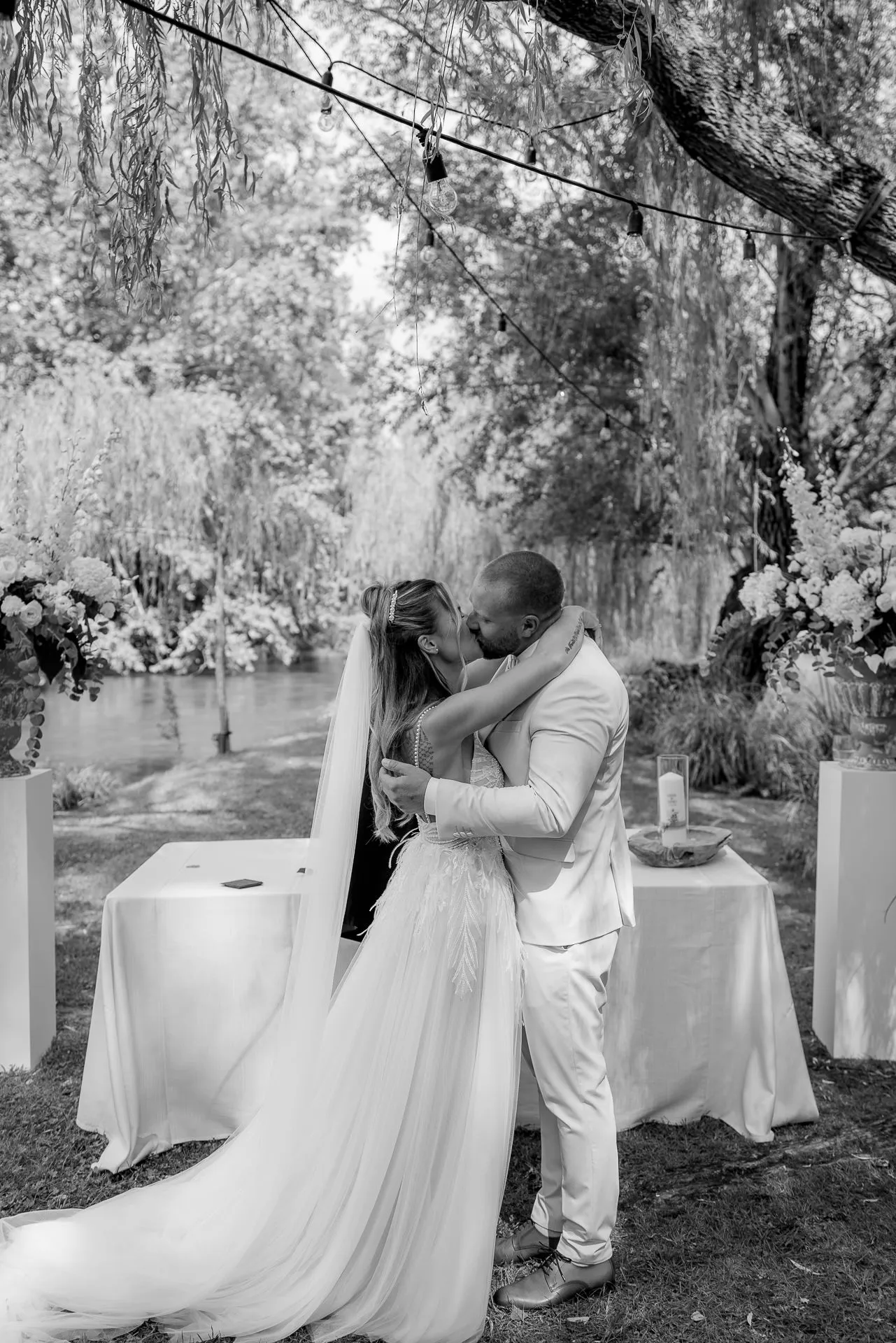 Romantic first kiss as married couple in black and white by the riverside