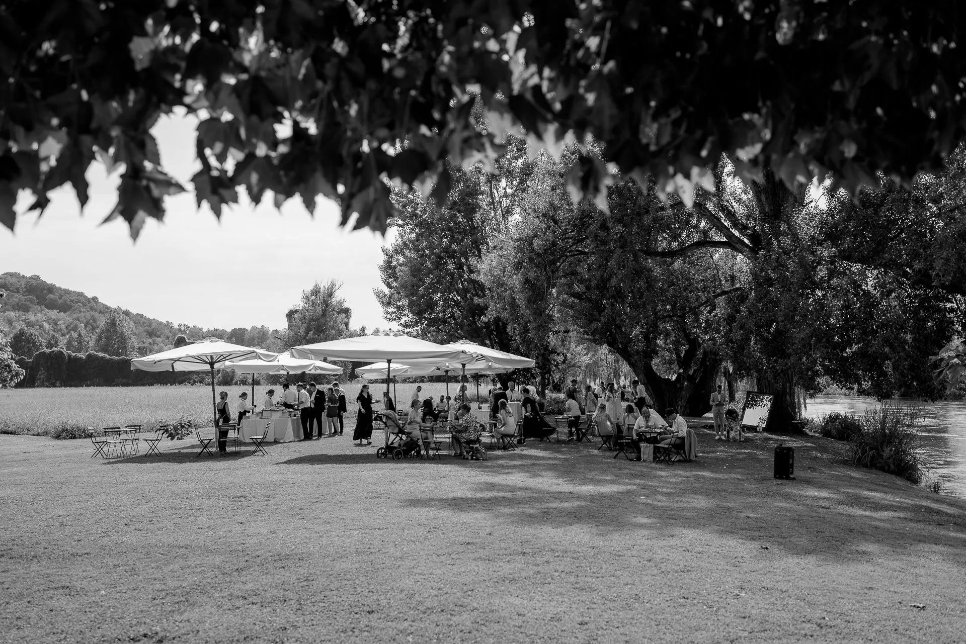 Cocktail reception by the riverside under shady trees in Italy