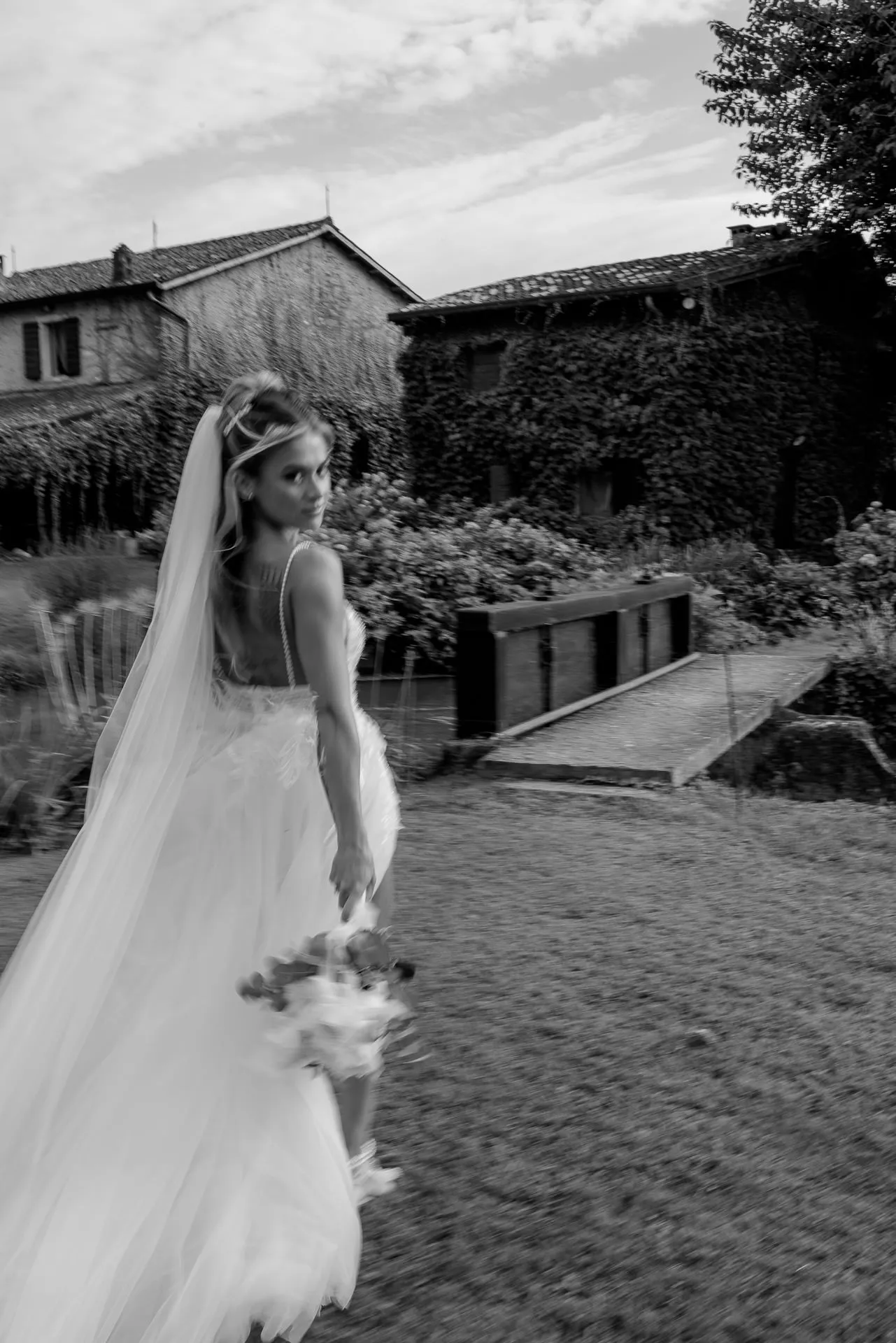 Bride in motion at La Finestra sul Fiume with flowing dress by river