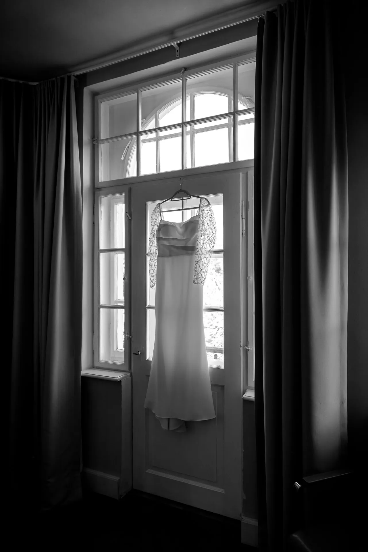Wedding dress hanging in window in black and white at Gut Sonnenhausen wedding