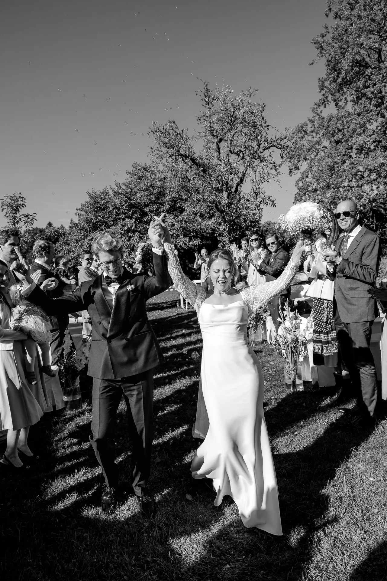 Bride celebrating joyfully after ceremony at Gut Sonnenhausen in black and white
