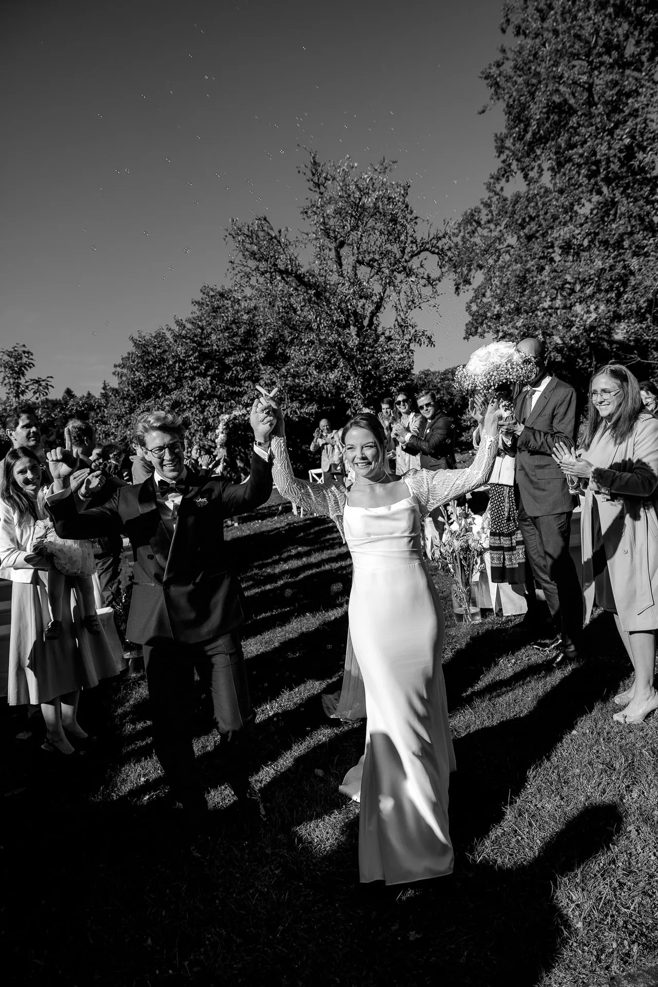 Jubilant bride with outstretched arms after wedding at Gut Sonnenhausen