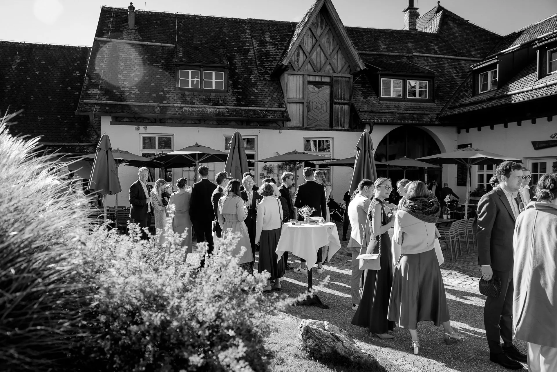 Cocktail hour in courtyard at Gut Sonnenhausen wedding in black and white
