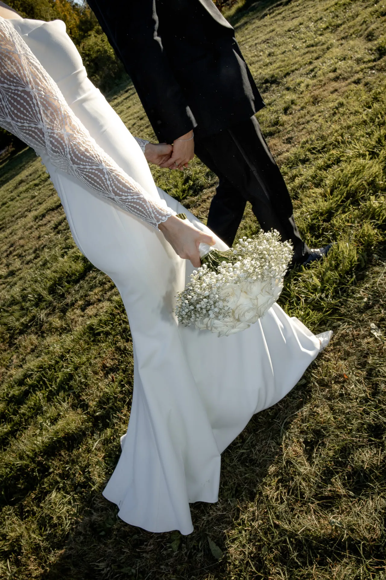 Bride and groom walking hand in hand with bouquet at Gut Sonnenhausen wedding