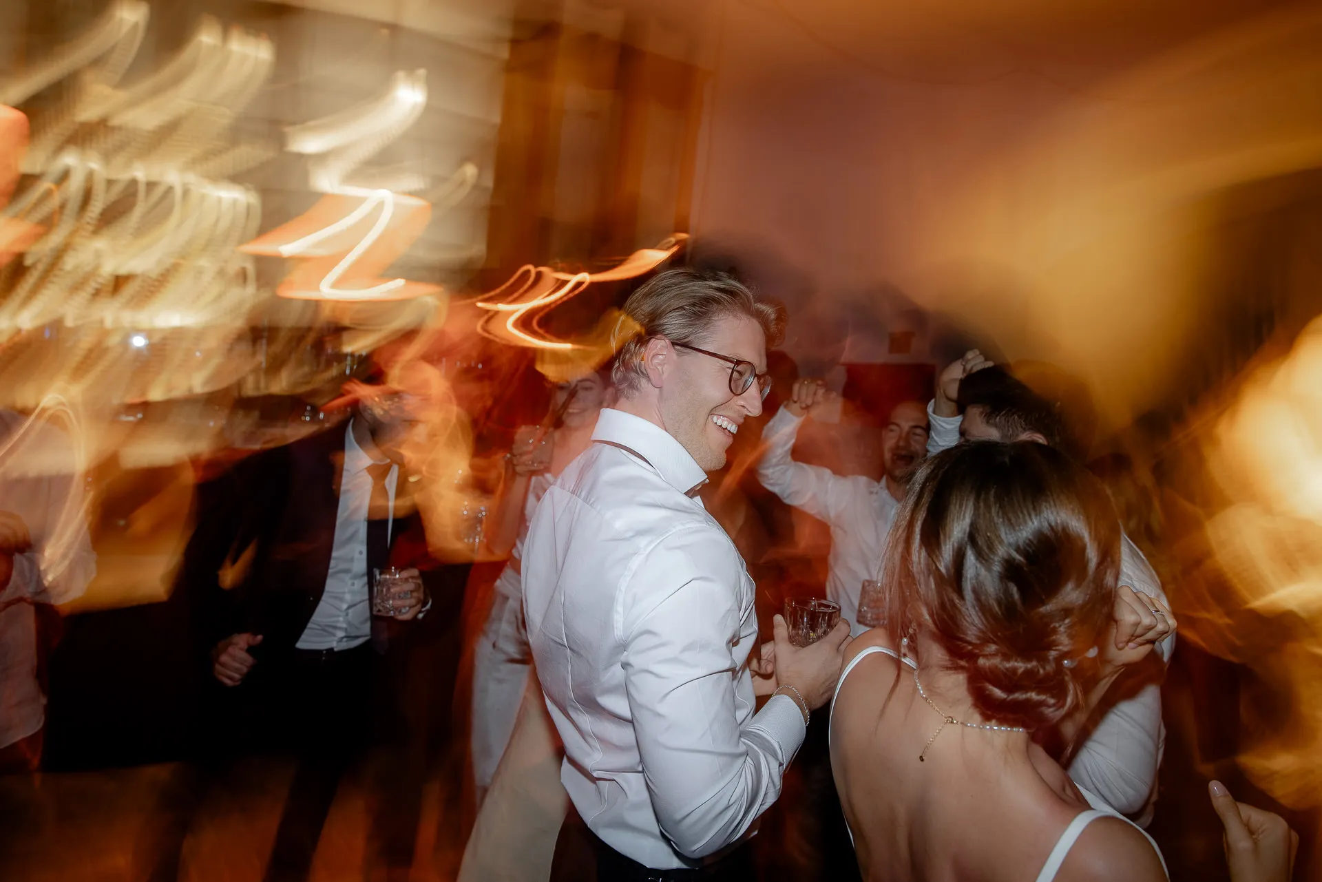 Wedding guests dancing joyfully at celebration at Gut Sonnenhausen country wedding