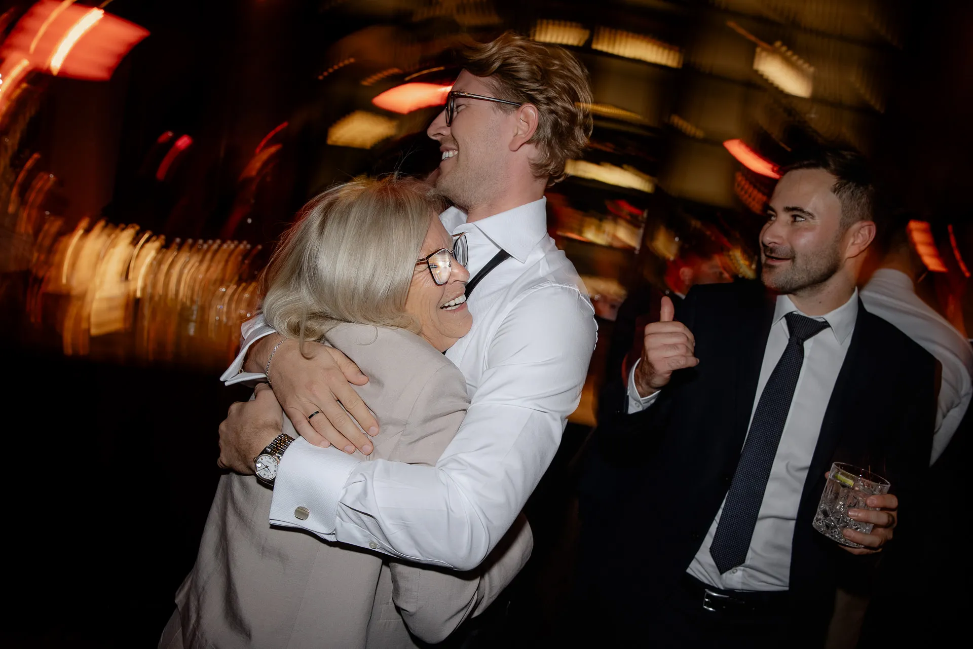 Joyful wedding guests embracing at celebration at Gut Sonnenhausen wedding