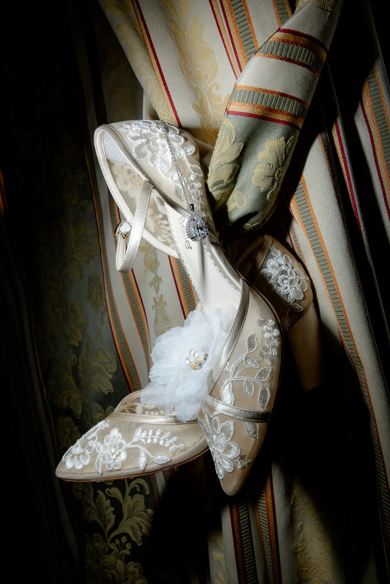 Detail shot of decorated bridal shoes with lace on antique upholstery