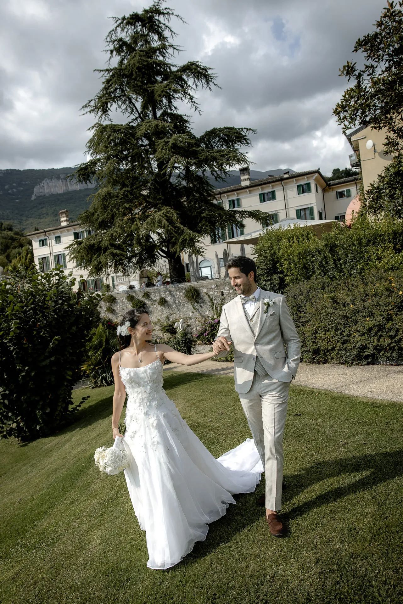 Elegant wedding couple in front of Villa Cariola with dramatic cloudy sky
