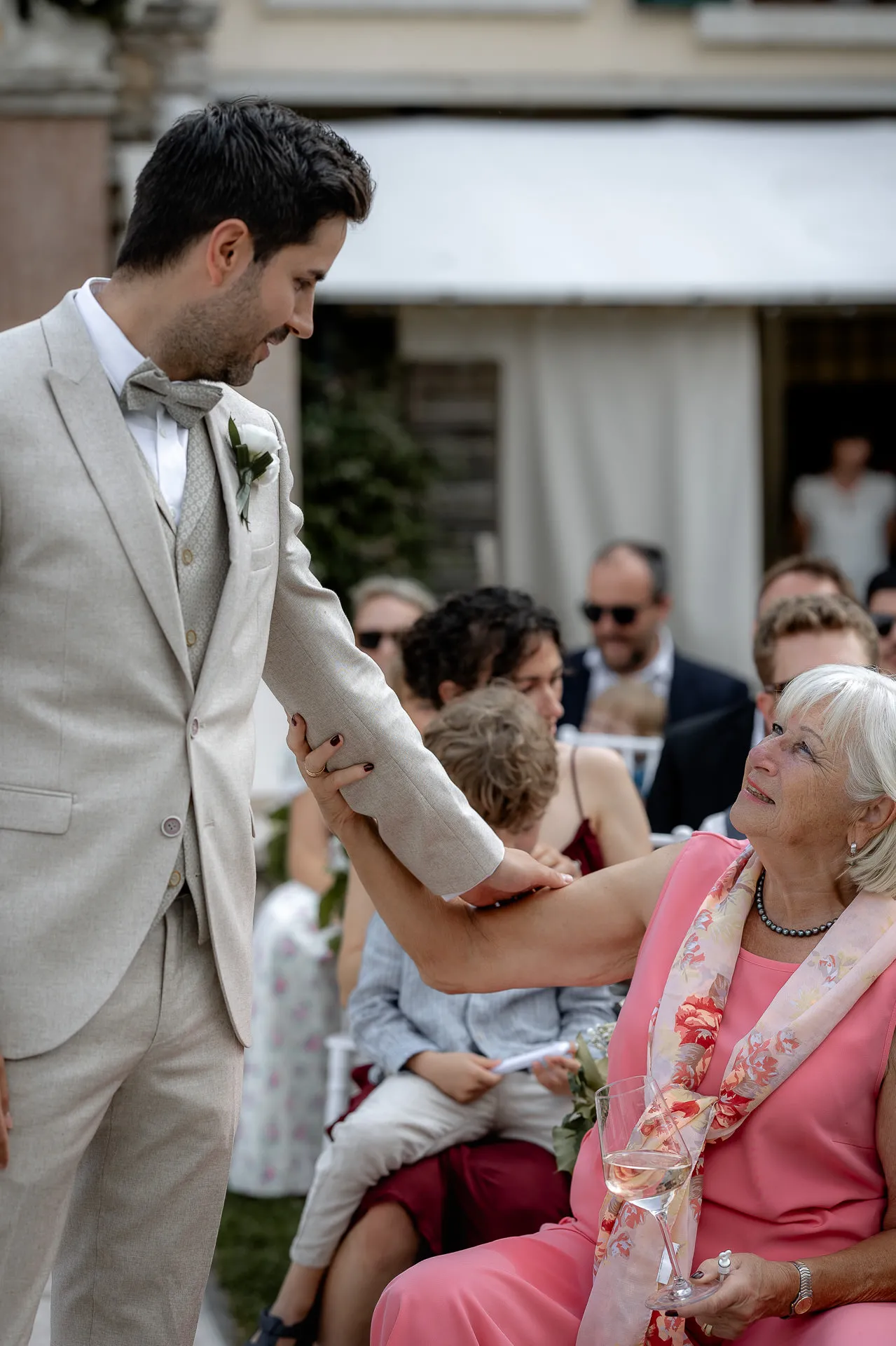 Emotional moment between groom and grandmother at wedding ceremony