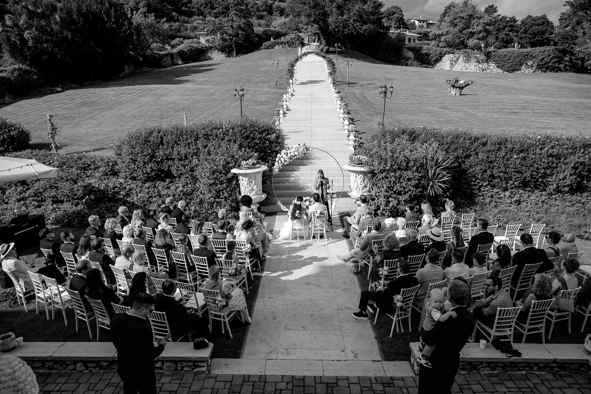 Bird's eye view of outdoor ceremony with floral arch at Villa Cariola