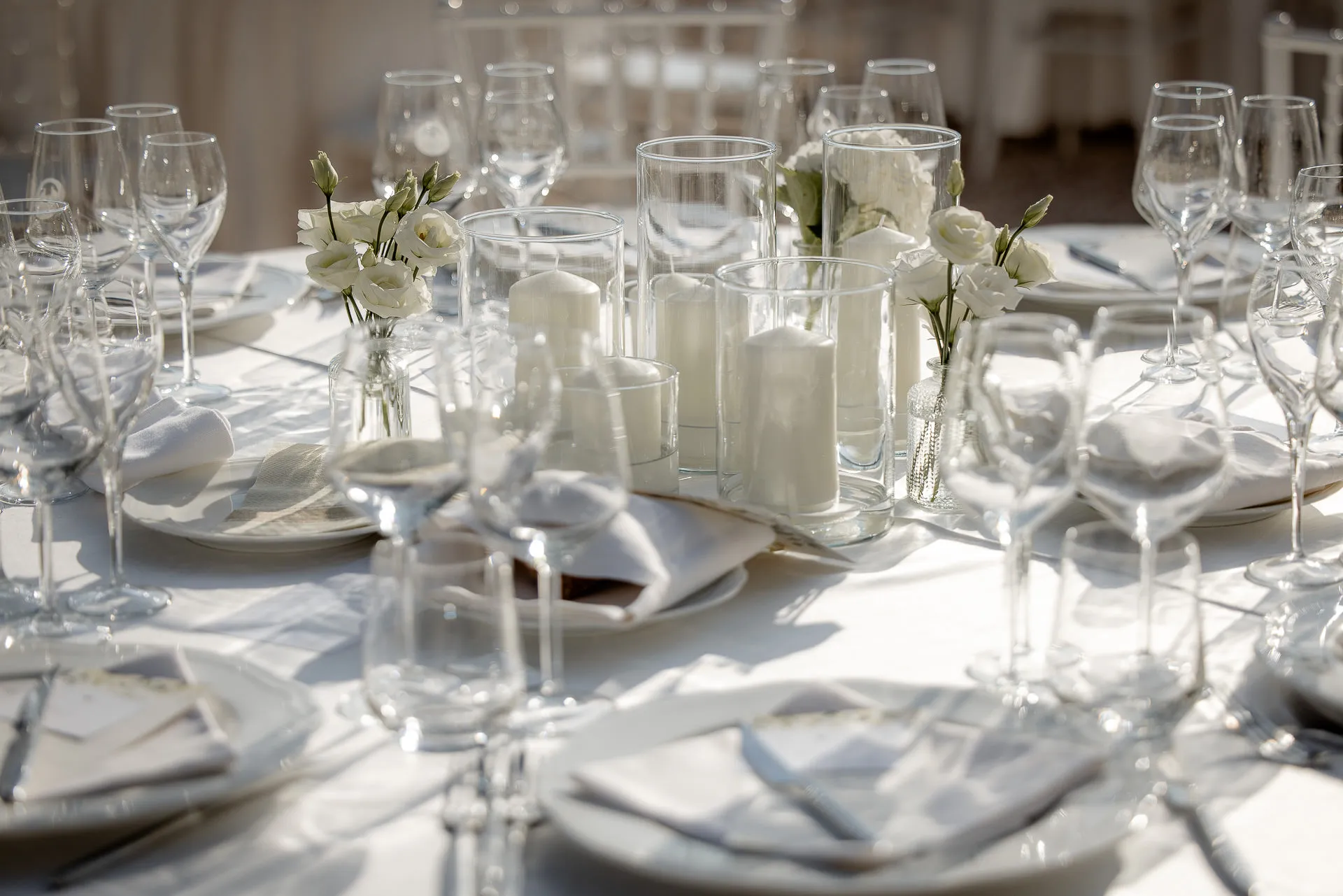 Luxurious white wedding table setting with candles and white roses at Villa Cariola
