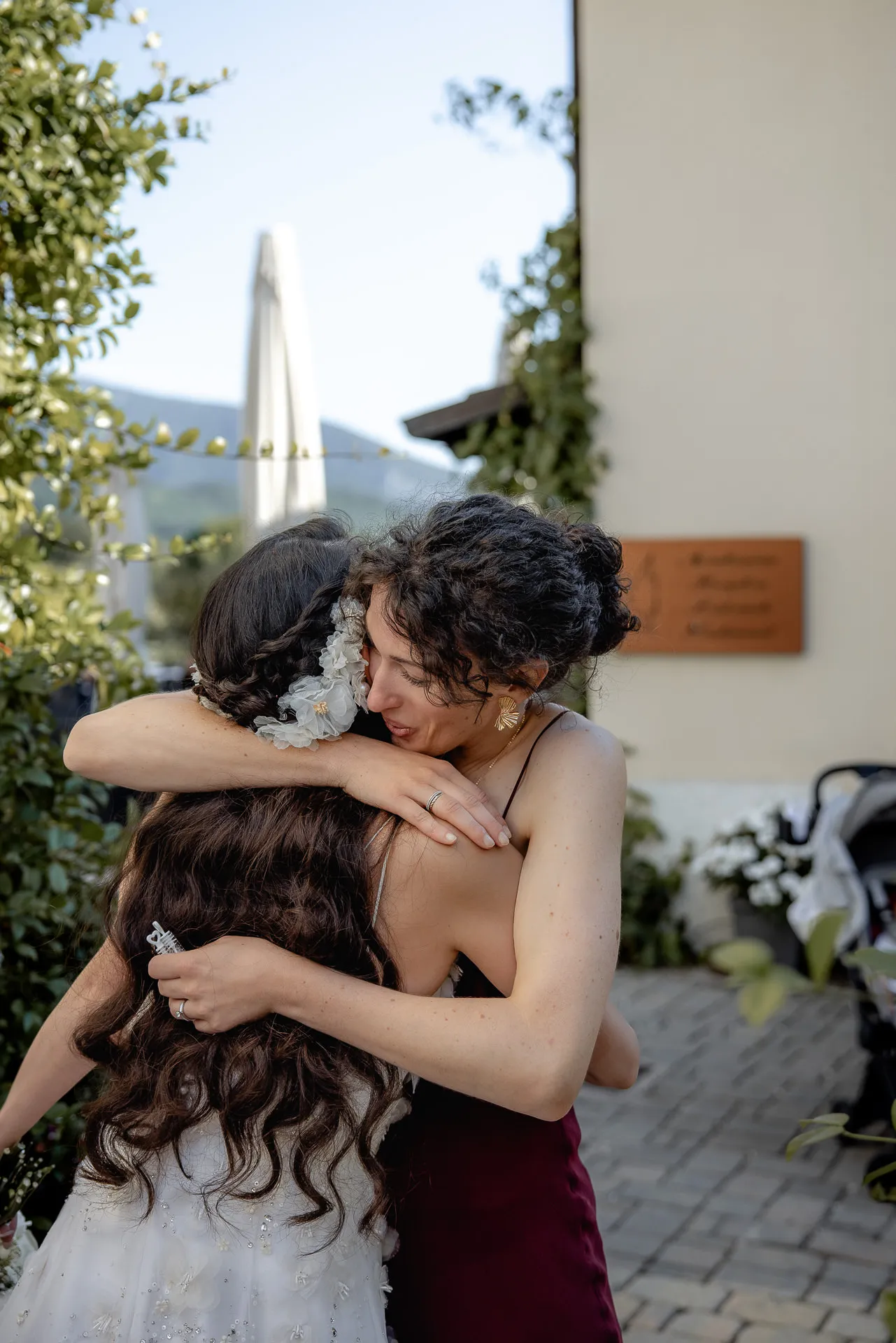 Emotional embrace of bride with wedding guest in front of Villa Cariola