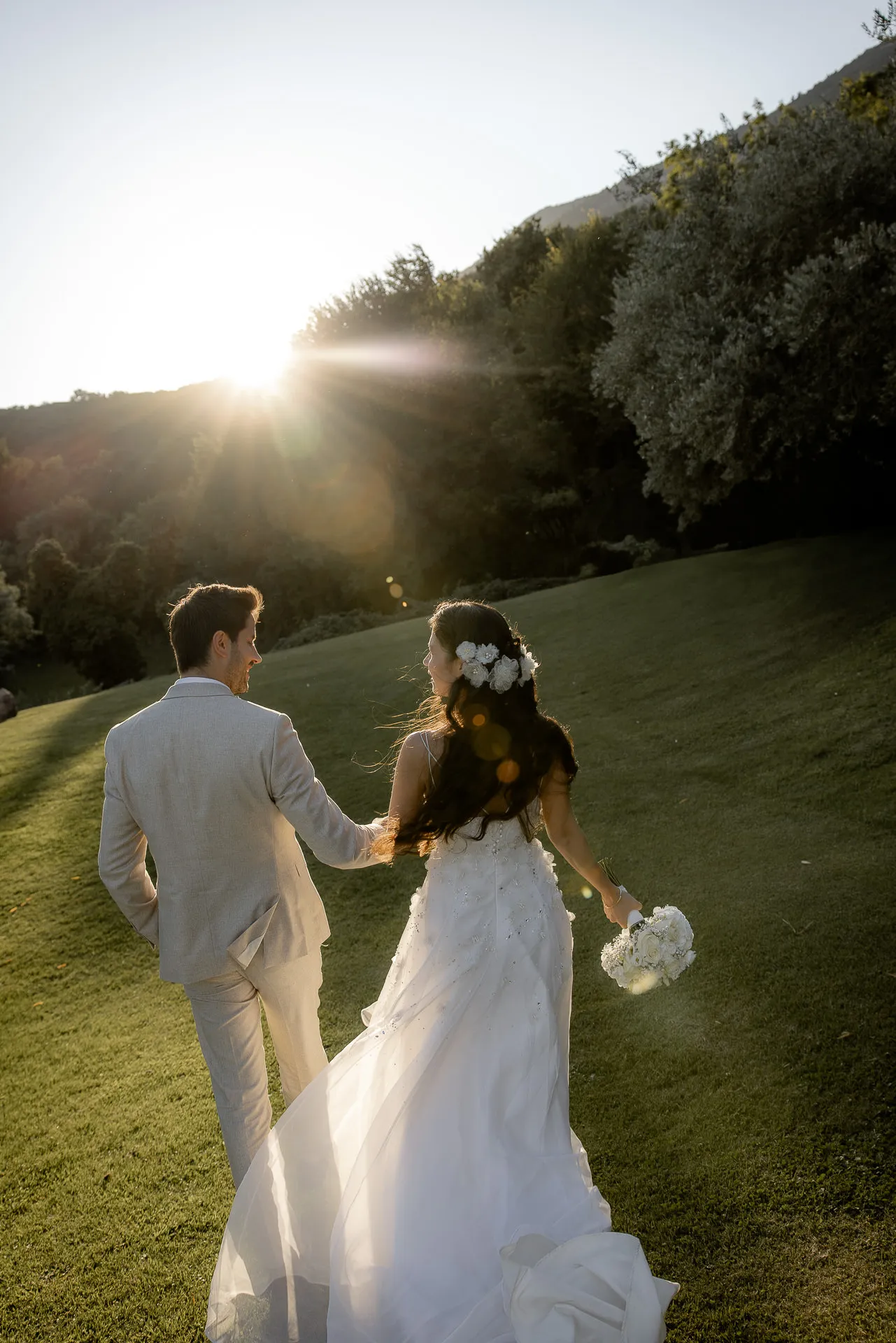 Loving wedding couple hand in hand at sunset at Villa Cariola