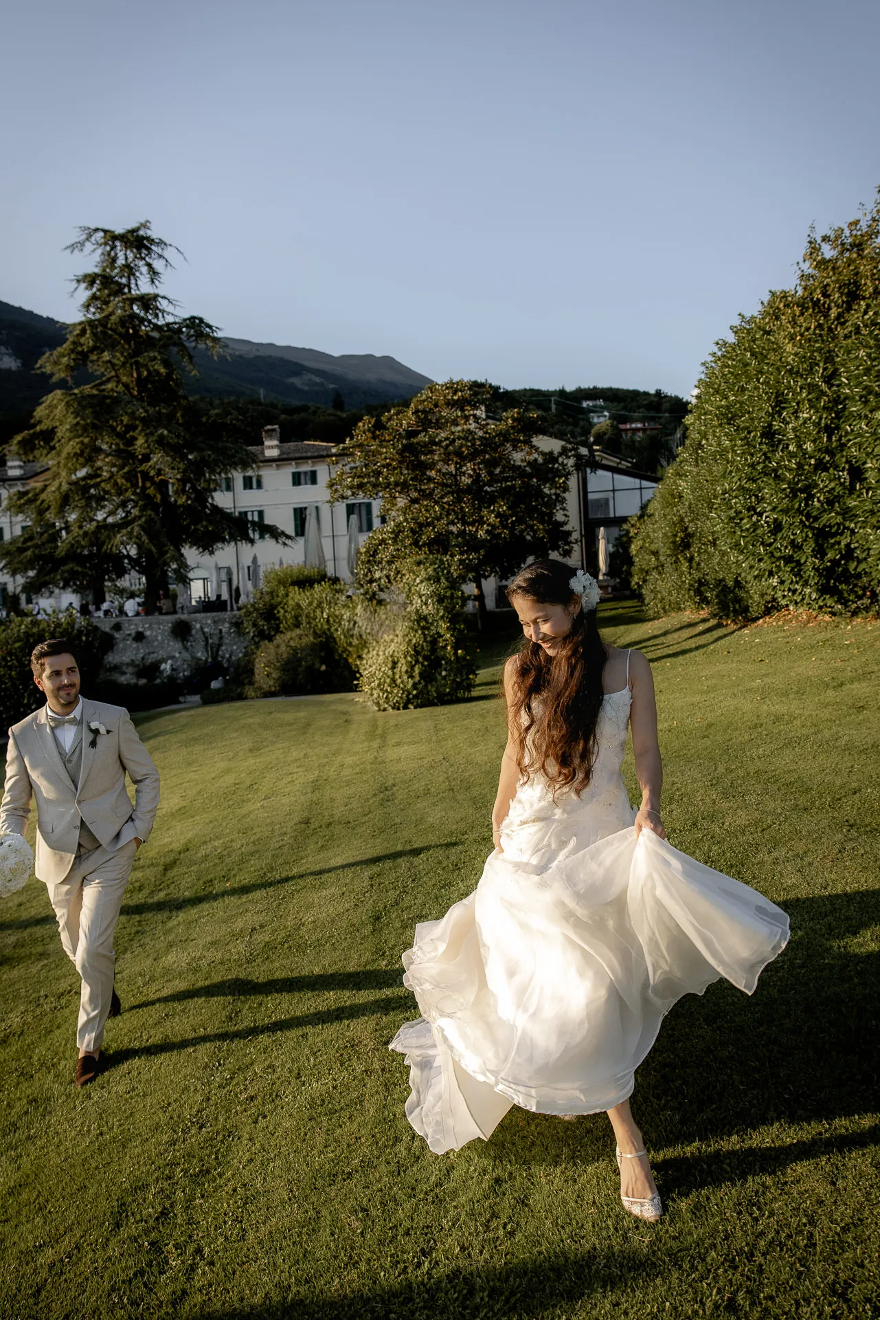 Bride with flowing dress running through park at Villa Cariola at dusk