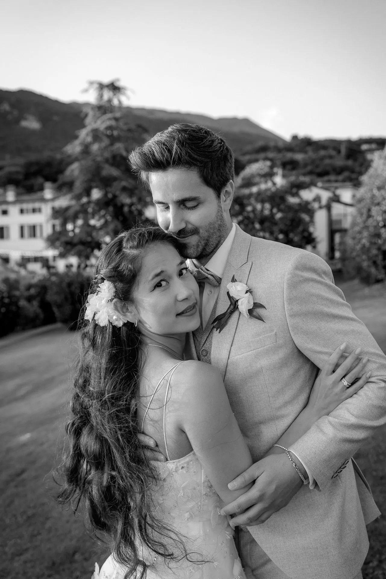 Loving wedding couple in black and white in front of Italian landscape at Lake Garda