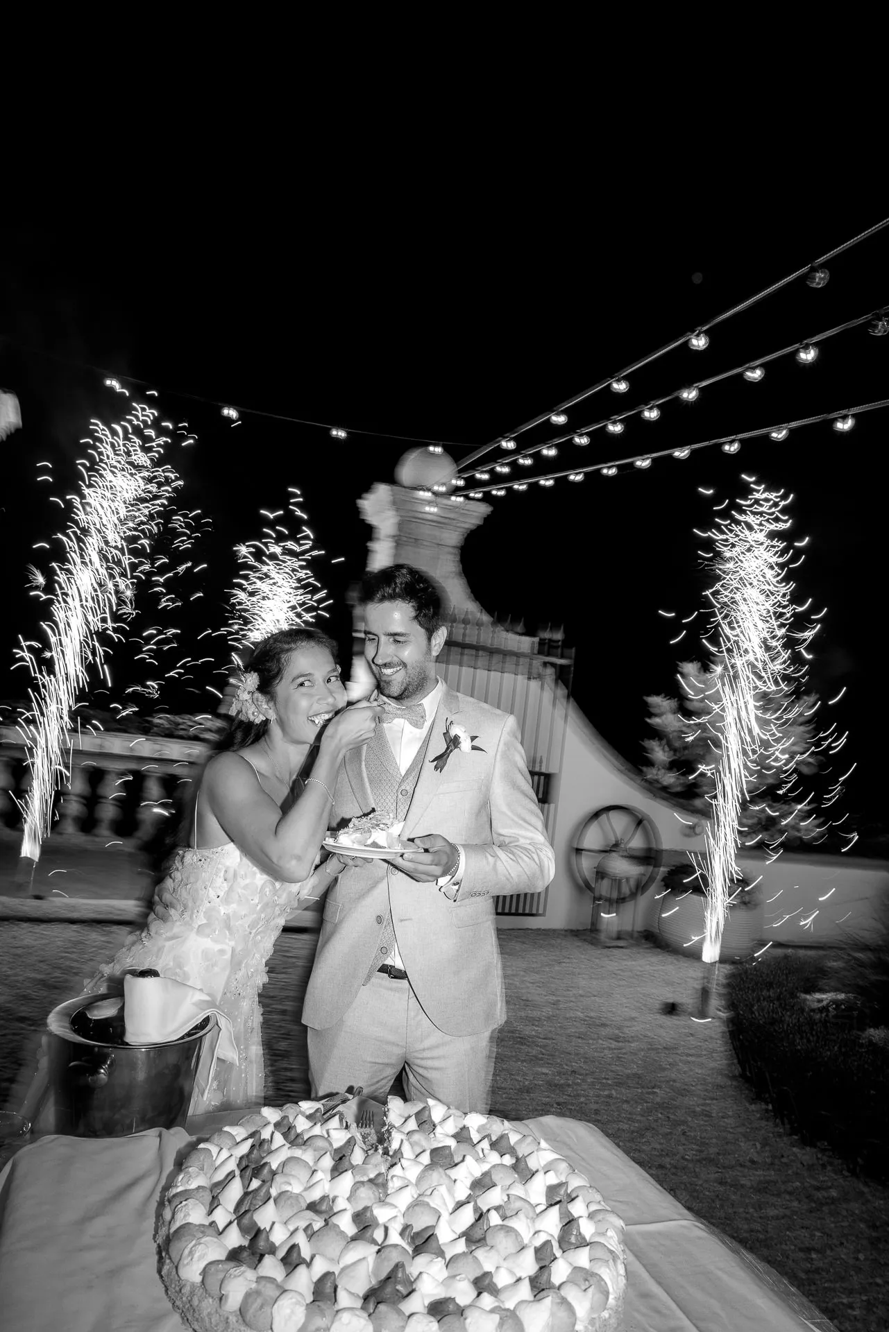 Bride and groom cutting wedding cake with fireworks at luxury wedding in Italy
