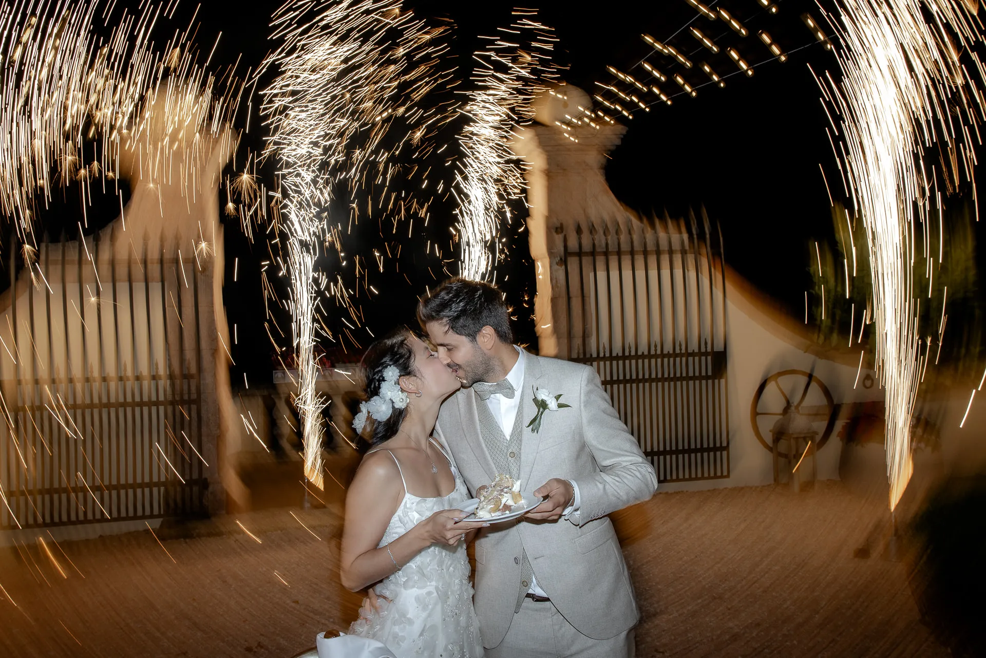Wedding couple kissing during fireworks at cake cutting at Lake Garda